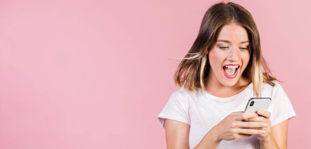 girl with pink background visiting a facebook page on her phone