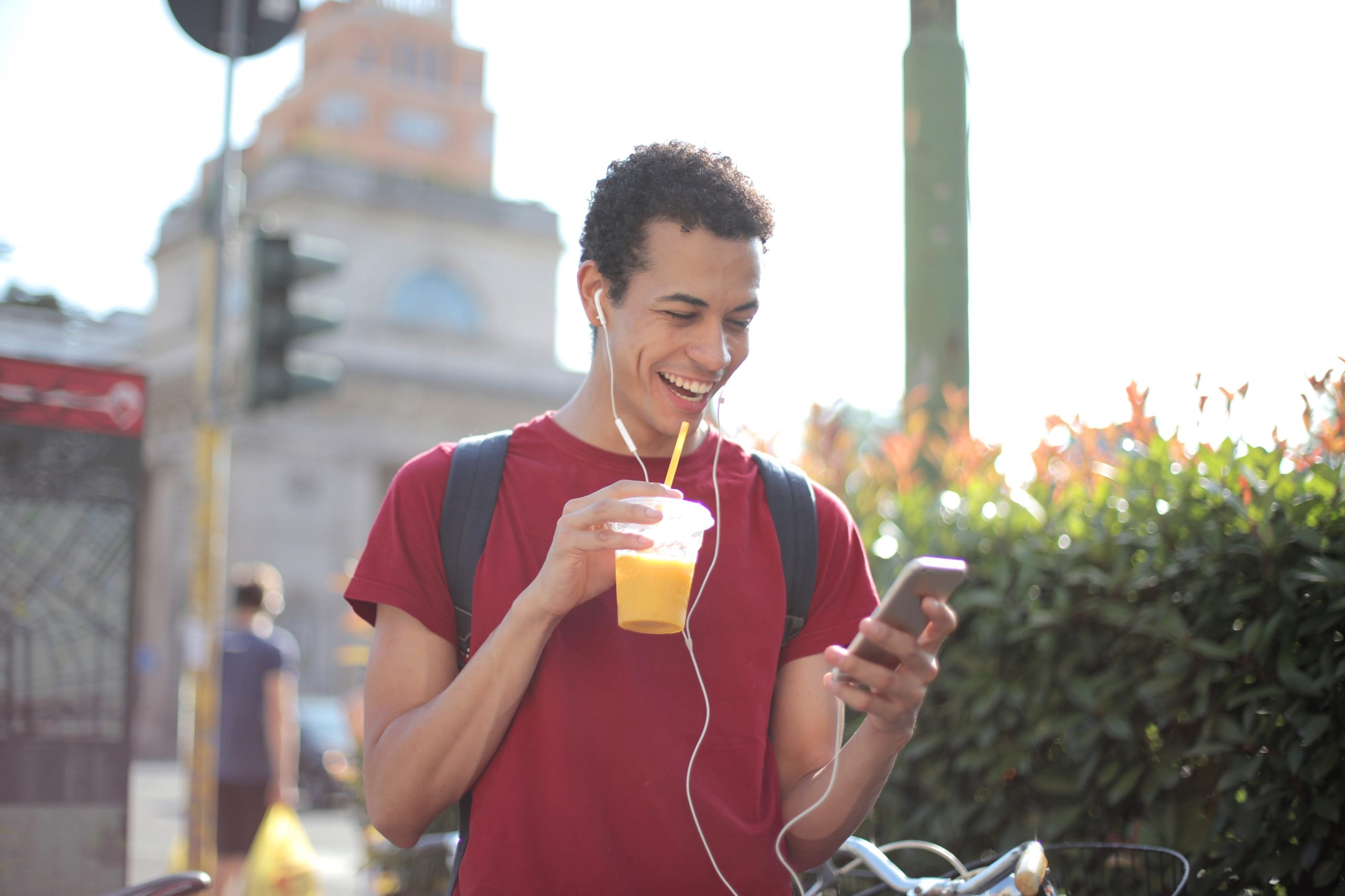 young man happy on cell phone with beverage