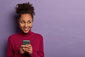 Woman smiling while using phone (1)